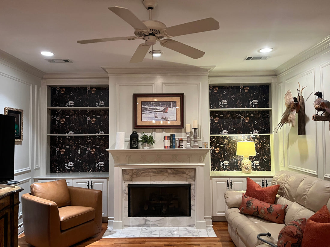 Finished built-in bookshelves with dark floral wallpaper backing, styled with ceramic pieces and books