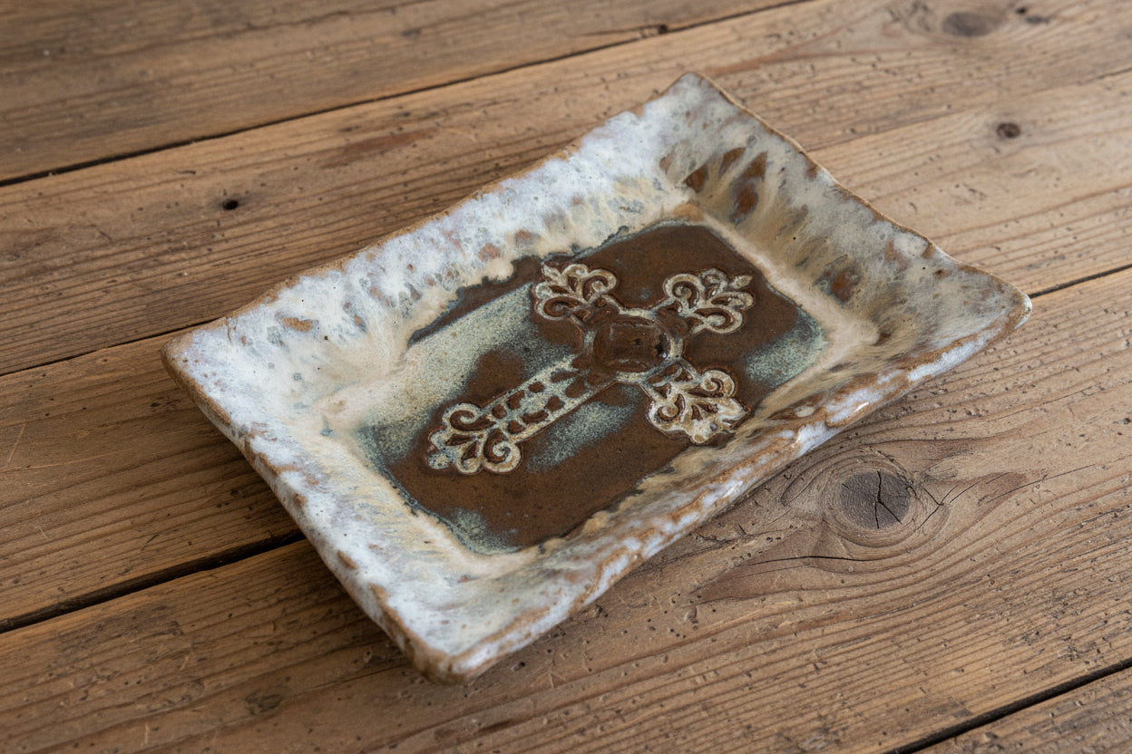 Rectangular ceramic tile with decorative cross design on a beige background
