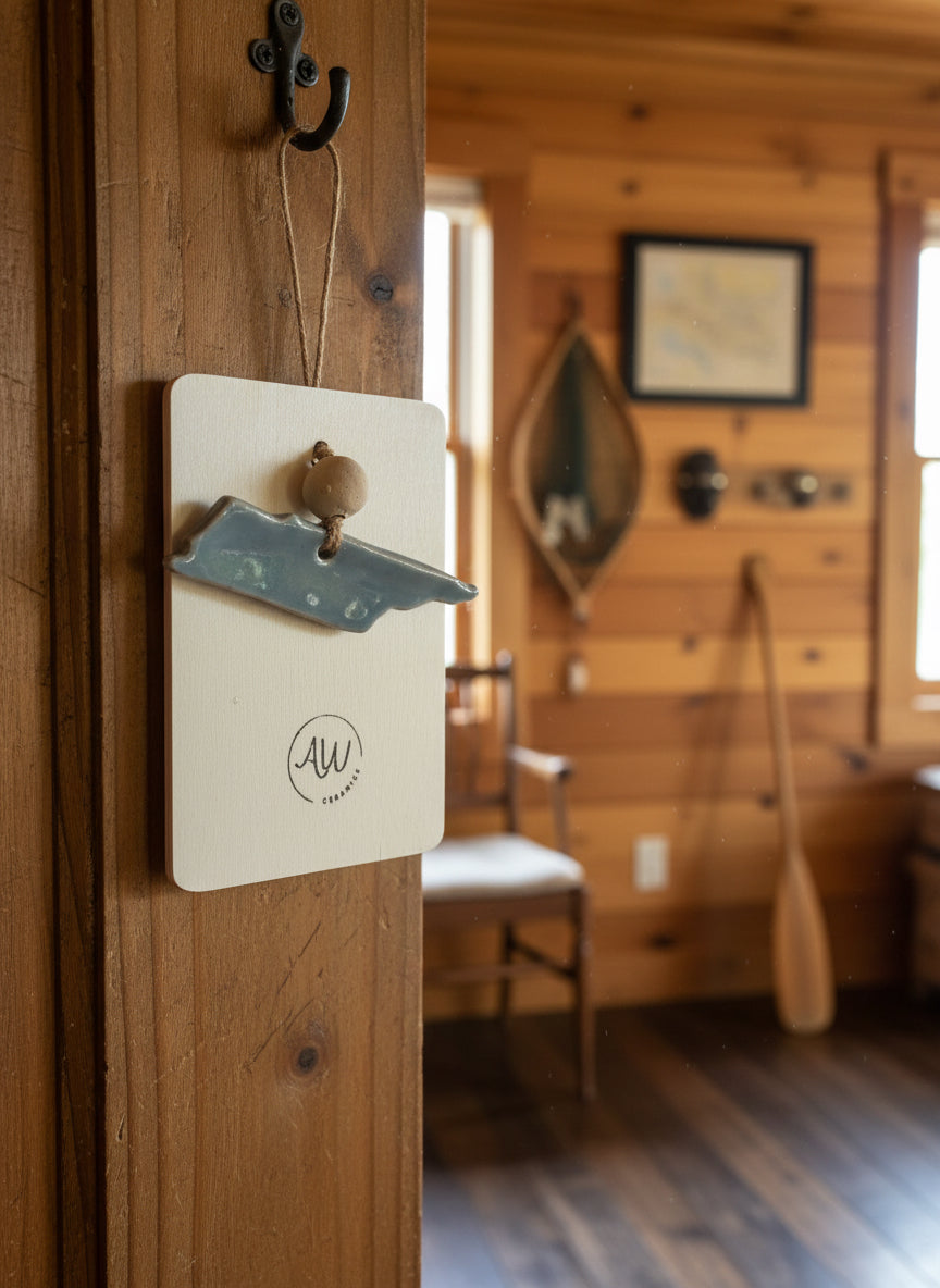 a blue ceramic Tenessee ornament hanging on a door inside a cabin